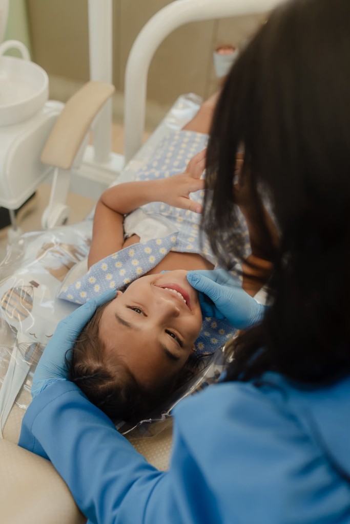 Criança sorrindo durante atendimento odontopediátrico na Clínica Evident